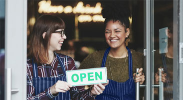cafe owners with an open sign